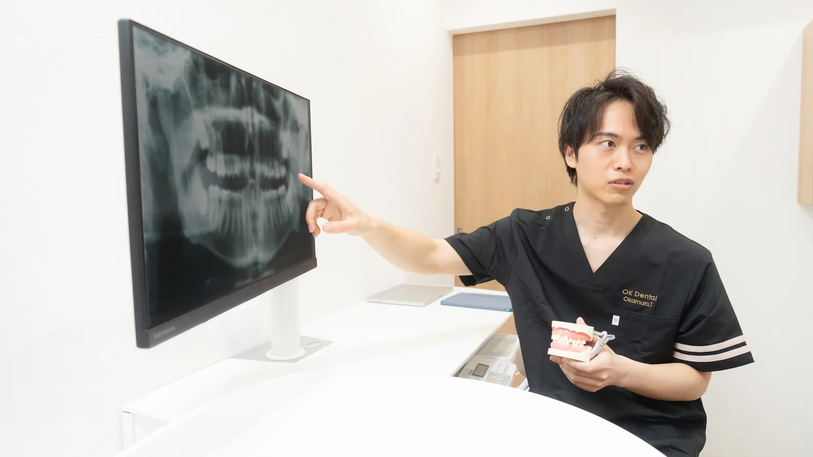 パノラマレントゲンを一緒に見ながら治療方針を説明する歯科医師と患者